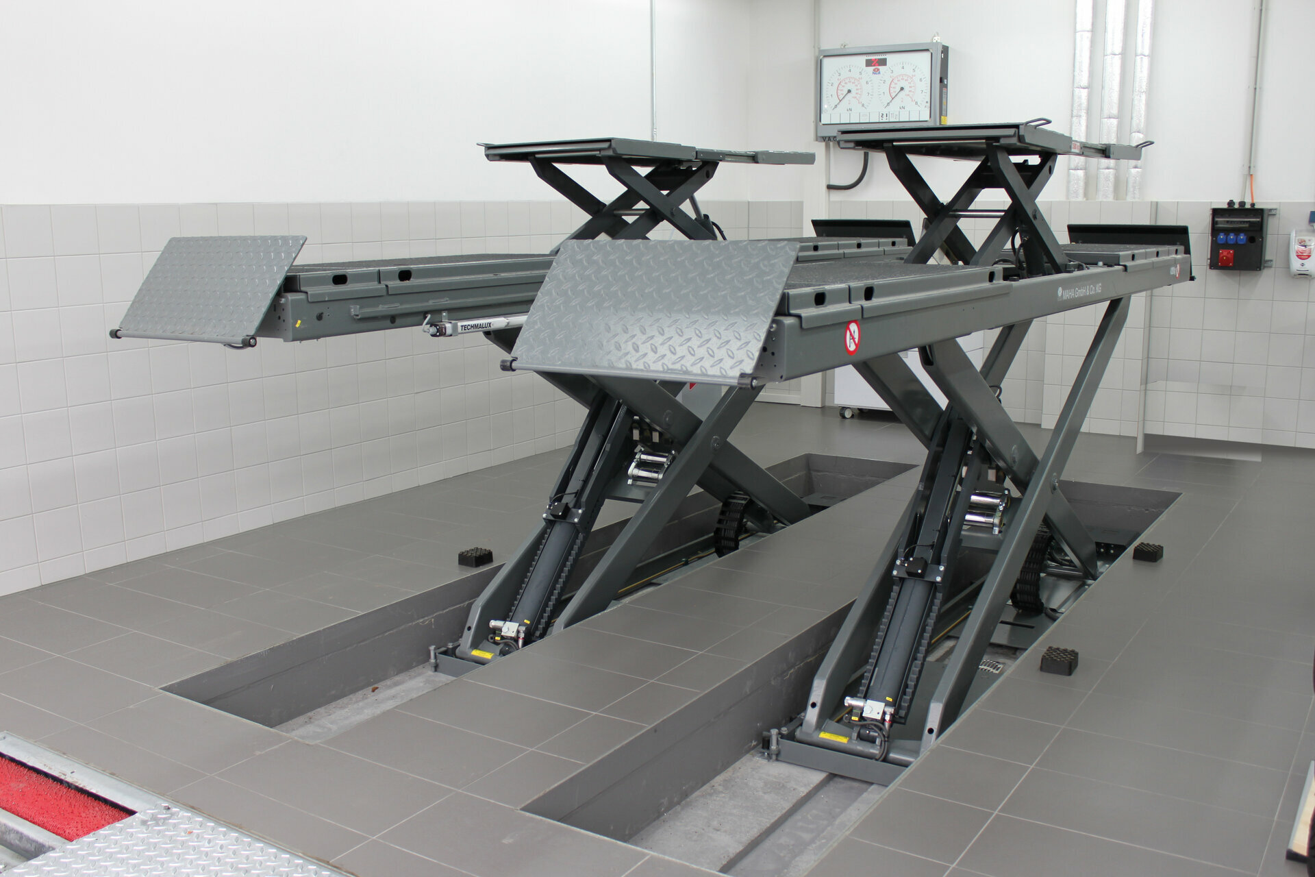 Versatile MAHA UK DUO CM scissor lift braced for MOT and wheel ...